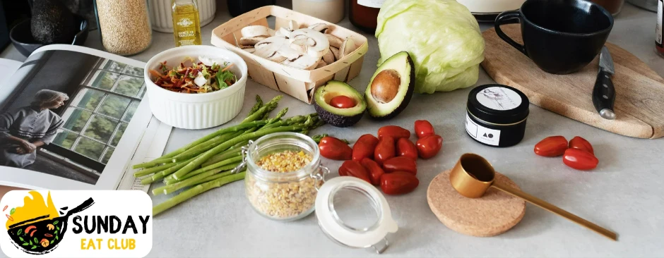 avocados and tomatoes among other vegetables on a table. sunday eat club